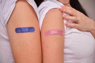 Young couple with bandage on their arms after receiving vaccination, Woman and man after vaccine wearing white t shirts at home , covid delta omicron vaccine concept