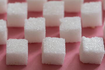 Sugar cubes on pink background