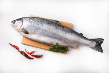 A whole salmon carcass on a chopping board. Red fish delicacy