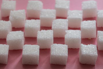 Sugar cubes on pink background