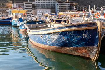 Close-up detail view old wooden vintage colorful bright fishing ships moored at fisherman village marina clear water bay on bright sunny day. Sea harbor with traditional retro vessels background