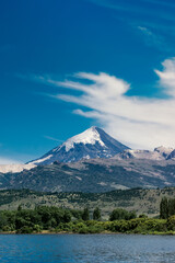 Fototapeta premium Top of volcano peak mountain with snow under the blue sky with grass field and steppes. 