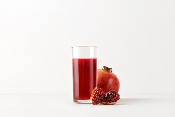 Fresh pomegranate juice in glass  with fresh pomegranate fruits on white background for menu and mock up