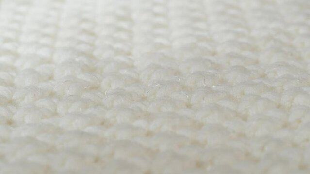 White knitted cloth, light woolen clothes fabric close-up, woven textile background.