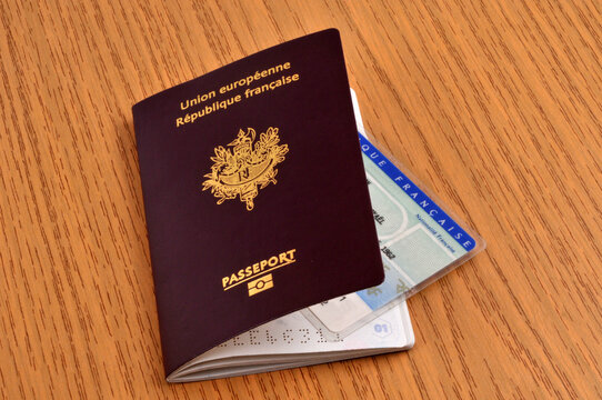 Passeport biométrique français avec une carte d'identité dedans sur une table en bois