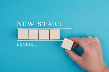 Words new start coming with a loading bar, hand puts last cube to the line, beginning a business,...