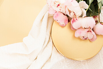 Styled composition with pink tulips on gold background. Flat lay floral frame and white textile. Border top view.