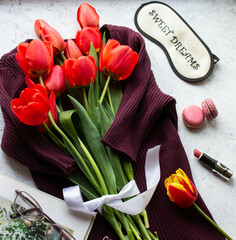 a bouquet of red tulips lies on a gray background, a female concept, the minimalism of international women's Day
