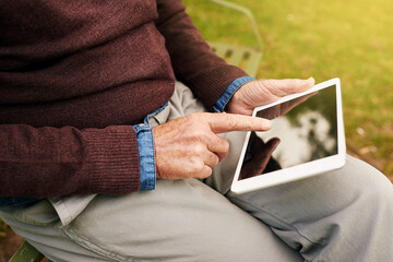 Information at your fingertips. Closeup shot of a man using a digital tablet in the park.