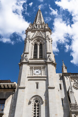 Fototapeta na wymiar Front facade of Santiago Cathedral main tower in Bilbao old town under intense blue sky with clouds