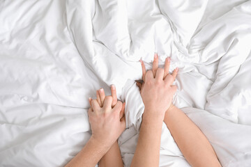 Hands of couple having sex on bed, top view - obrazy, fototapety, plakaty