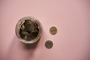 monety w słoiku na różowym tle,polski złoty	