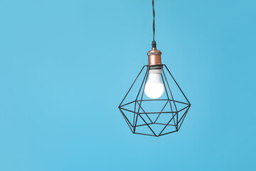 Stylish pendant lamp on blue background