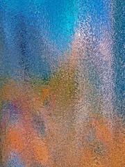 Beautiful, bright, unusual background created by abstract patterns, formed by multi-colored lighting of the embossed glass surface