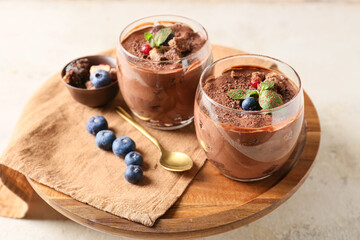 Stand with glasses of sweet cocoa dessert on grunge background