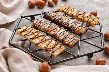 Rack with tasty chocolate nut bars on grunge background