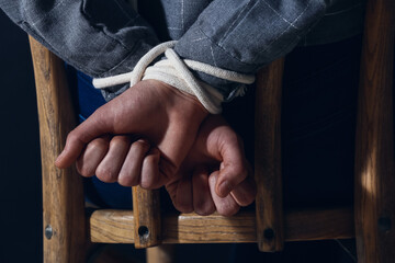 Hostage with tied hands sitting on chair, closeup - obrazy, fototapety, plakaty