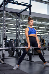 Fototapeta na wymiar adult woman doing heavy duty squat in gym with barbell. caucasian Woman with perfect abs and strong legs doing squat exercises.Confident fit woman in great shape in Fitness gym, alone