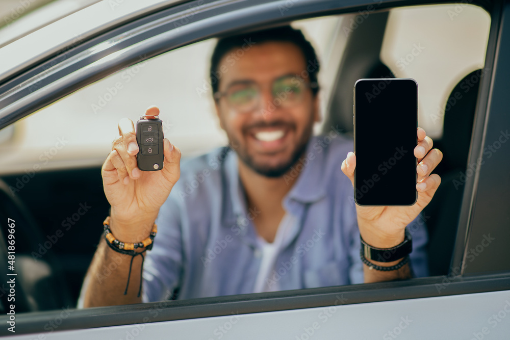 Wall mural Auto key and smartphone with empty screen in male hands