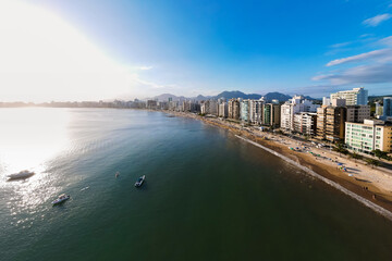 Imagem de drone da Praia do Morro em Guarapari num dia ensolarado com muitas pessoas se divertindo,...