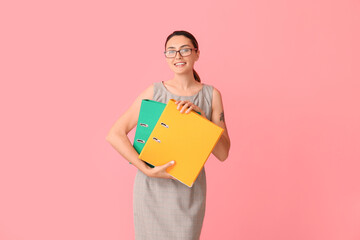 Beautiful young woman with folders on color background