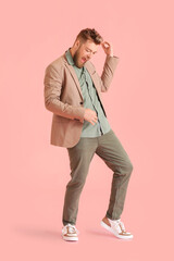 Cool dancing young man on color background