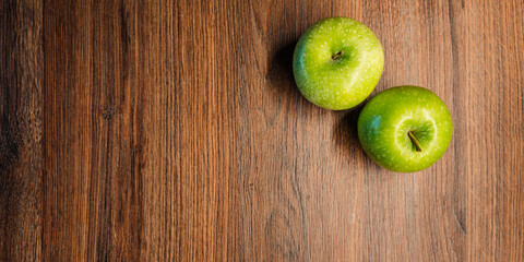 2 grüne saftige Äpfel auf rustikalem Holztisch