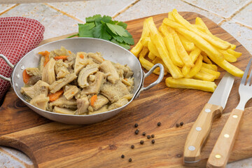 dish of tripe and fries on a table	