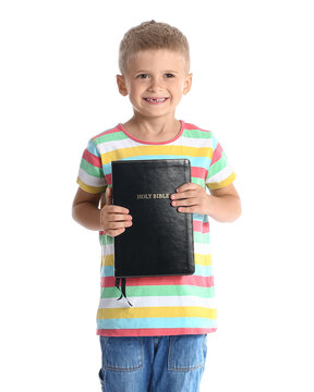 Adorable little boy with Holy Bible on white background