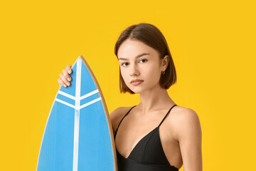 Beautiful young woman with surfboard on color background
