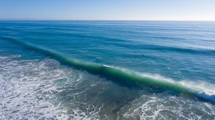 Aerial view of surfers riding waves in Spain. Atlantic surf at Trafalgar drone view