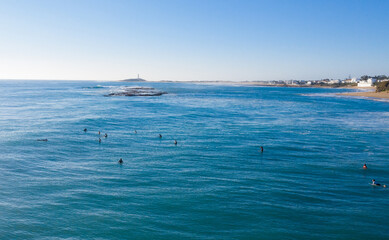 Aerial view of surfers riding waves in Spain. Atlantic surf at Trafalgar drone view