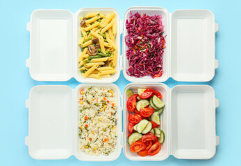 Food delivery containers with different delicious meals on color background