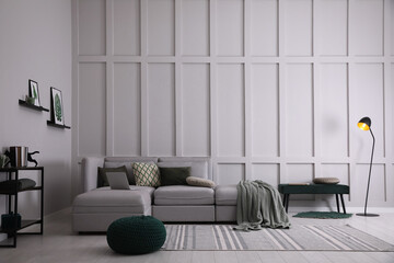 Living room with comfortable grey sofa and stylish interior elements