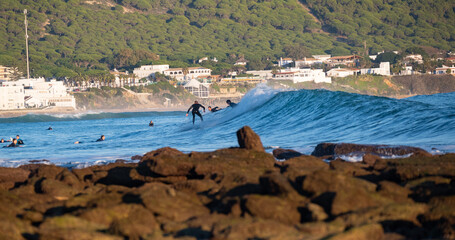 Surfers riding waves in Los Caños de Meca, South Spain