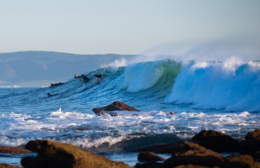 Surfers riding waves in Los Caños de Meca, South Spain