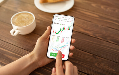 Female hands holding cellphone with trading mobile app