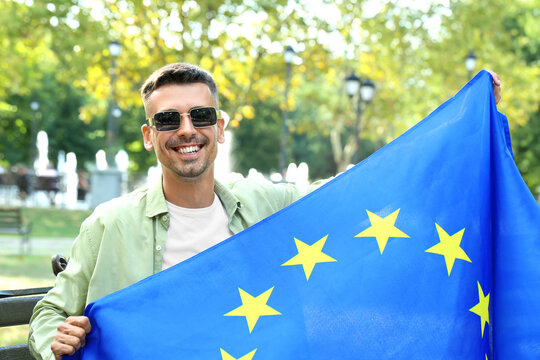 Young man with flag of European Union in park