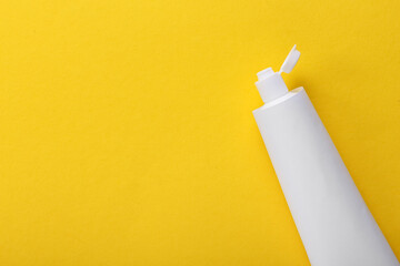 Tube with tooth paste on yellow background