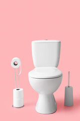 Holder with rolls of paper, toilet bowl and brush on color background