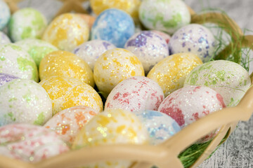 Multi-colored small eggs close-up in a basket. Easter
