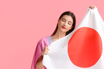 Beautiful young woman with flag of Japan on color background