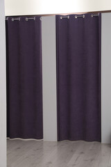 Dressing rooms with stylish purple curtains in fashion store