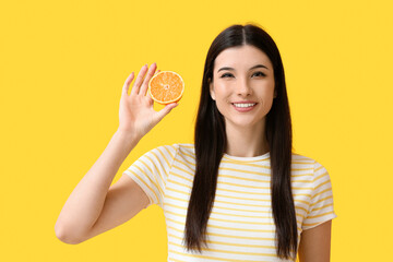 Pretty young woman with orange on color background