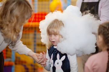 White smoke around the girl's head. Liquid nitrogen at the party. Portrait of a child, laughter and...