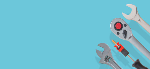 Banner with a set of workshop tools with shadows at solid turquoise background with copy space. Concept of hardware, gears, and workshop work