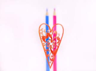 colored pencils on a white background. a couple in love. blue and pink pencils. colored pencils and a red heart