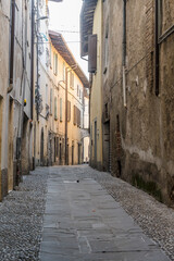 bending  cobbled narrow lane in historical town, Rovato, Italy