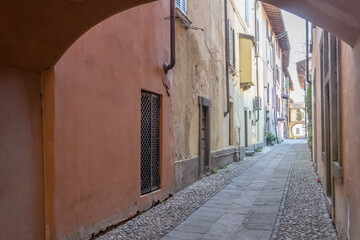 Fototapeta na wymiar old builings on cobbled narrow lane in historical town, Rovato, Italy