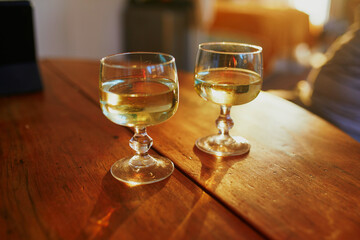 Two glasses of white wine on wooden table